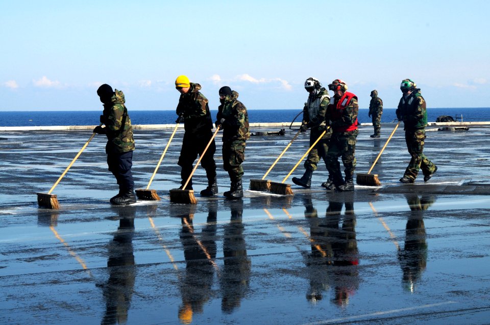 US Navy 110323-N-NB544-194 Sailors scrub the flight deck aboard the aircraft carrier USS Ronald Reagan (CVN 76) following a countermeasure wash dow