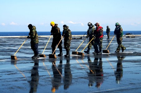 US Navy 110323-N-NB544-194 Sailors scrub the flight deck aboard the aircraft carrier USS Ronald Reagan (CVN 76) following a countermeasure wash dow