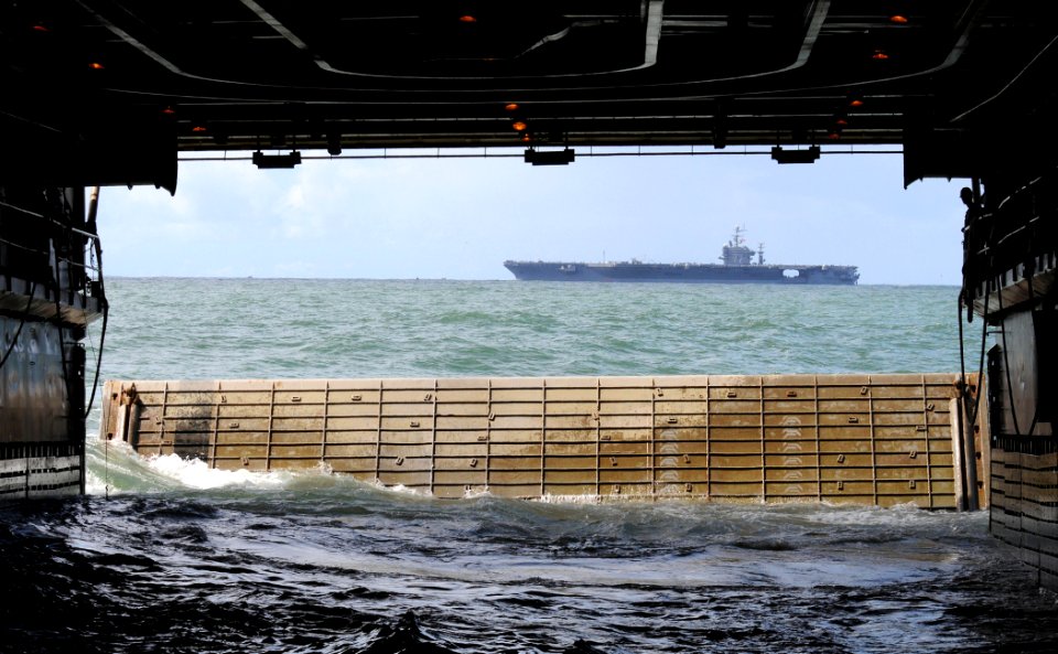US Navy 110321-N-KB563-650 The Nimitz-class aircraft carrier USS Abraham Lincoln (CVN 72) passes by as the amphibious transport dock ship USS Cleve