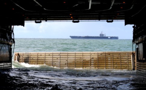 US Navy 110321-N-KB563-650 The Nimitz-class aircraft carrier USS Abraham Lincoln (CVN 72) passes by as the amphibious transport dock ship USS Cleve