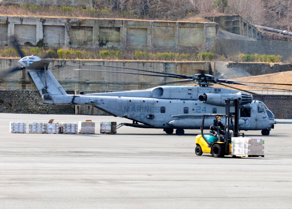 US Navy 110322-N-5538K-189 A Japanese man moves a pallet of humanitarian assistance and disaster relief supplies from a CH-53E Sea Stallion helicop