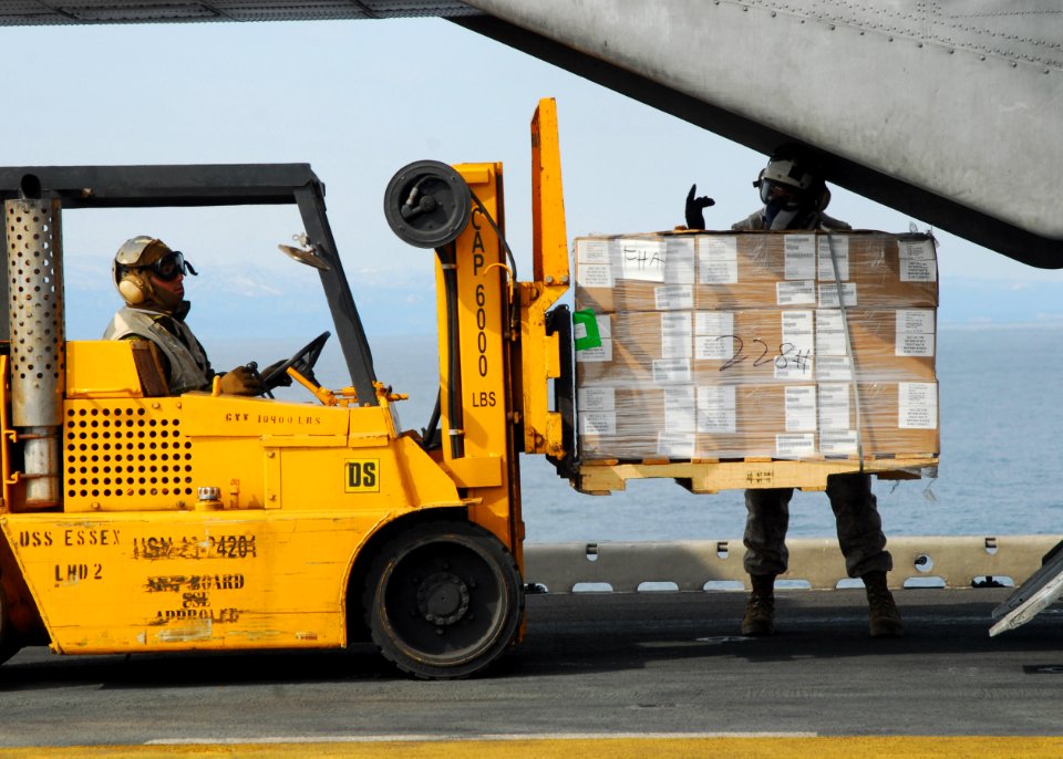 US Navy 110322-N-8607R-311 Marines load humanitarian assistance supplies onto a CH-53E Sea Stallion helicopter aboard the forward-deployed amphibio