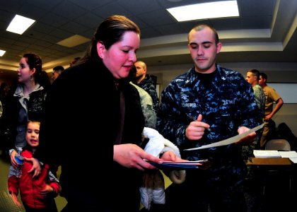 US Navy 110324-N-4044H-012 Yeoman 2nd Class Stephan Schreiber assists a Navy spouse with her travel claim after passing through customs and immigra