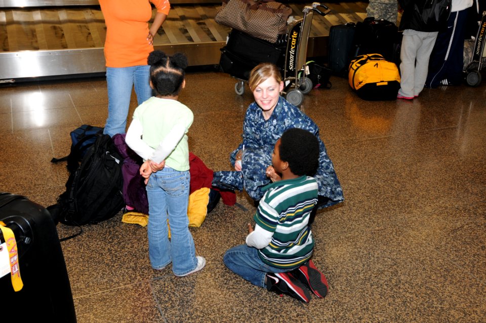 US Navy 110322-N-AE328-010 Aviation Ordnanceman 2nd Class Renee Duhaime entertains two young military family members while their mother waits for h