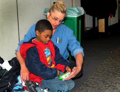 US Navy 110321-N-AE328-003 Terry Wimmer, a representative from Fleet and Family Support Center Naval Base Kitsap, plays video games with a child, w