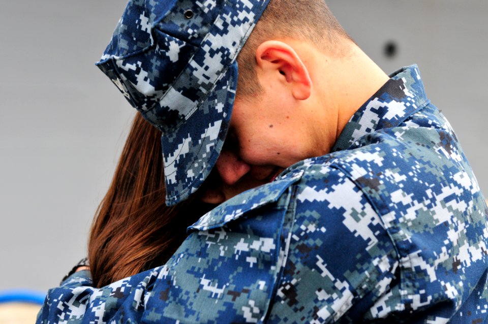 US Navy 110321-N-BT887-113 Culinary Specialist 3rd Class Abel Duran hugs his wife before deploying aboard the amphibious transport dock ship USS Cl