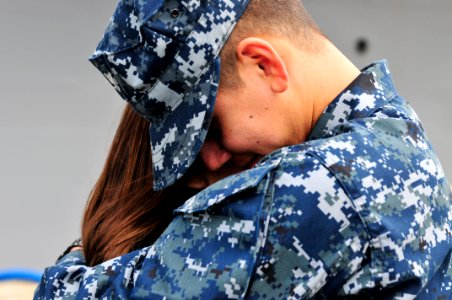 US Navy 110321-N-BT887-113 Culinary Specialist 3rd Class Abel Duran hugs his wife before deploying aboard the amphibious transport dock ship USS Cl