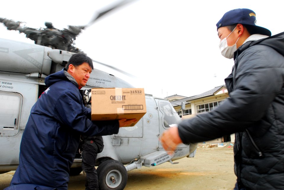 US Navy 110322-N-SB672-056 Japanese men unload humanitarian assistance supplies from an SH-60F Sea Hawk helicopter