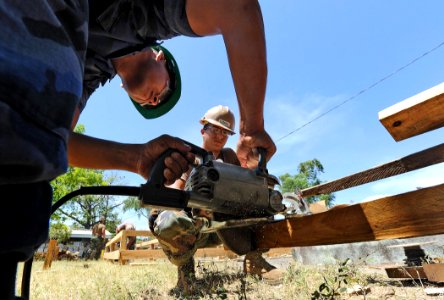 US Navy 110322-N-WX845-025 Equipment Operator 3rd Class John Guillen-Agudero, center, assigned to Naval Mobile Construction Battalion 28, serves as
