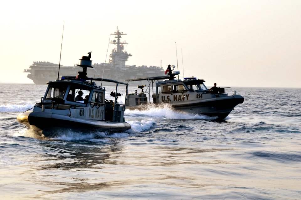 US Navy 110325-N-4228H-001 Sailors assigned to Maritime Expeditionary Security Squadron (MSRON) 5 and MSRON-9 escort the aircraft carrier USS Carl