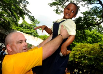 US Navy 110323-N-5085J-436 Navy Counselor 1st Class David Ferguson lifts a student during a community service project at La Briquetterie Government