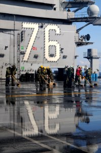 US Navy 110323-N-NB544-186 Sailors scrub the flight deck aboard the aircraft carrier USS Ronald Reagan (CVN 76) following a countermeasure wash dow