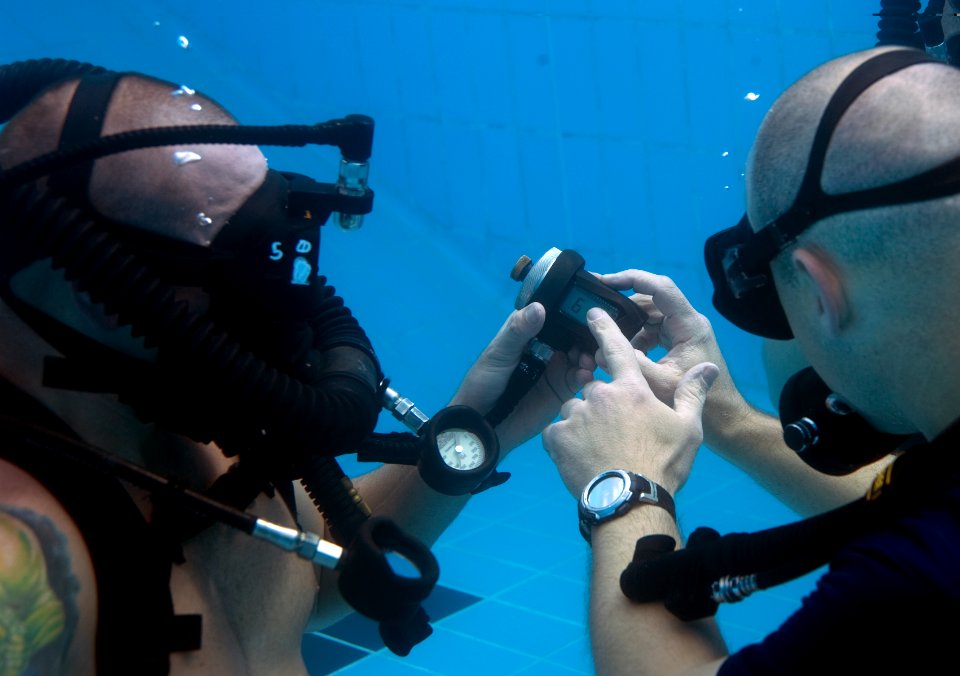 US Navy 110323-N-OT964-104 Navy divers assigned to Mobile Diving and Salvage Unit (MDSU) 2, check their gauges during a training dive to familiariz