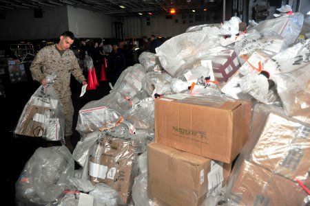 US Navy 110324-N-0074G-084 Lance Cpl. Joshua Kurtz sorts through pallets SS Enterprise (CVN 65).of mail received during an underway replenishment a