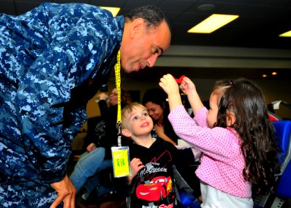 US Navy 110324-N-4044H-048 Navy chaplain Cmdr. Robert J. Thomas entertains children while their families wait for further instructions after passin