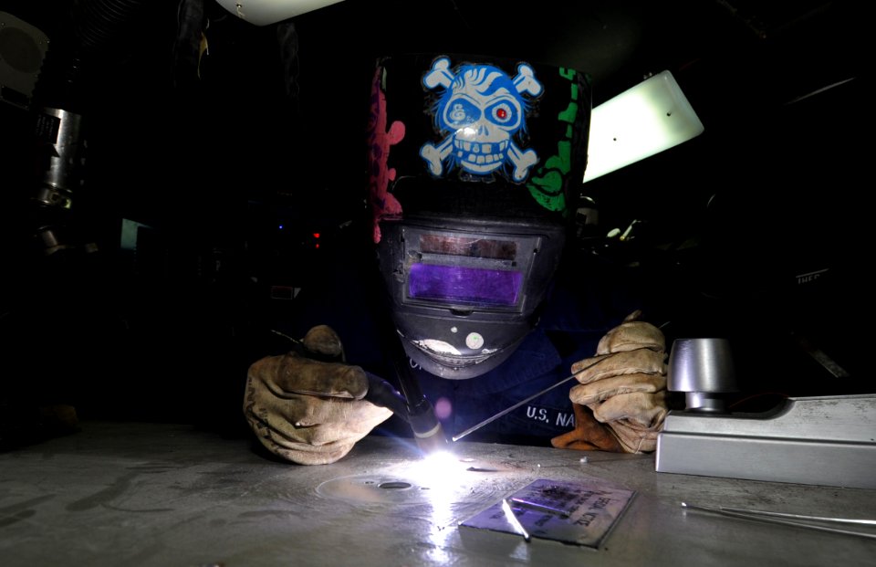 US Navy 110324-N-5031T-109 Hull Technician Fireman Eric Taylor, from Mansfield, Ohio, restores a door in the sheet metal shop