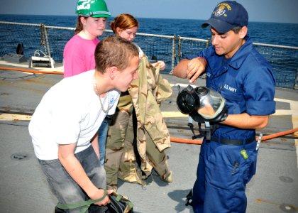 US Navy 110324-N-AW702-006 Damage Controlman Fireman Joe Hellow explains the importance of Mission Oriented Protective Posture (MOPP) gear to Rafea
