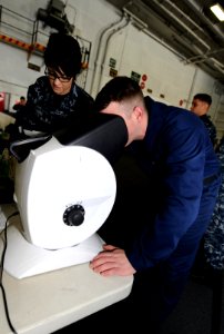 US Navy 110324-N-OY799-117 Hospital Corpsman Seaman Sara Tobias, from Puyallup, Wash., administers a vision test to Air Traffic Controller Airman A