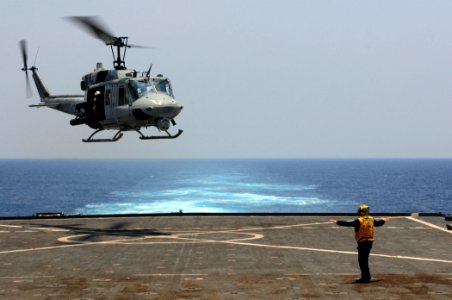 US Navy 110324-N-RC734-160 Boatswain's Mate 2nd Class Randy Buono, from Lewiston, Idaho, signals the pilot of a UH-1 Huey helicopter