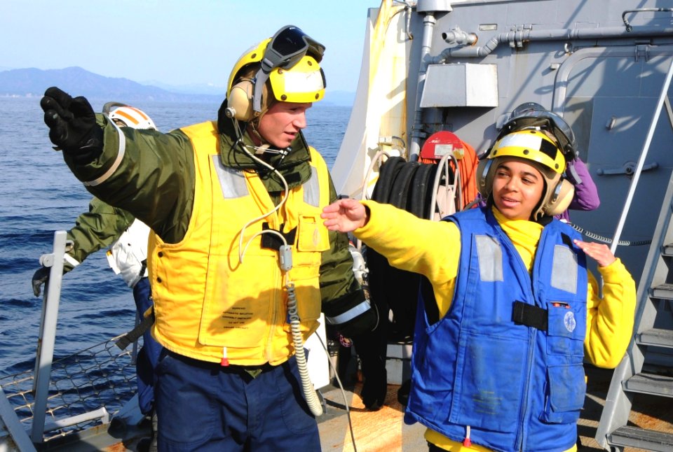 US Navy 110325-N-8288P-018 Boatswain's Mate 3rd Class Michael Davidson, left, assigned to the Arleigh Burke-class guided-missile destroyer USS Fitz