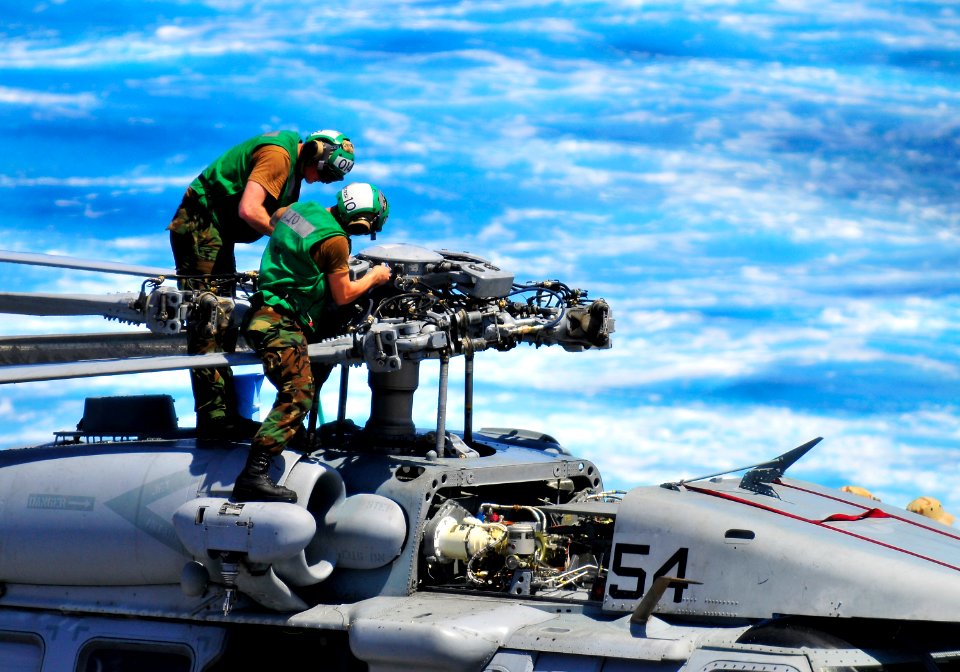 US Navy 110325-N-KB563-025 Sailors adjust the rotors of an MH-60S Sea Hawk helicopter on the flight deck aboard the amphibious transport dock ship