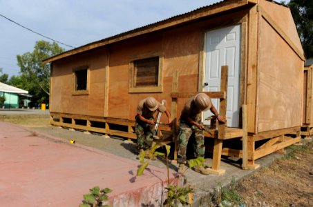 US Navy 110329-N-WX845-034 Sailors assigned to Naval Mobile Construction Battalion (NMCB) 28 finish a Southeast Asia hut at Instituto Parroquial Pb photo