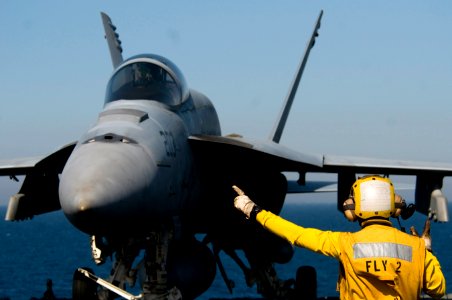 US Navy 110330-N-6320L-026 Aviation Boatswain's Mate 2nd Class Mario Billote directs an F-A-18E Super Hornet