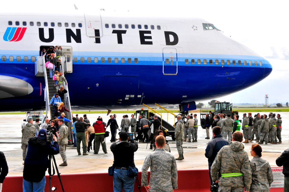US Navy 110325-N-4044H-106 U.S. Air Force and Navy personnel wait to assist military families exiting an aircraft from Japan during Operation Pacif