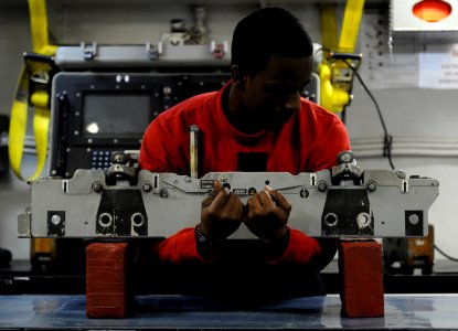 US Navy 110328-N-8040H-131 Aviation Ordnanceman 3rd Class James Bell places a bomb rack onto a work bench