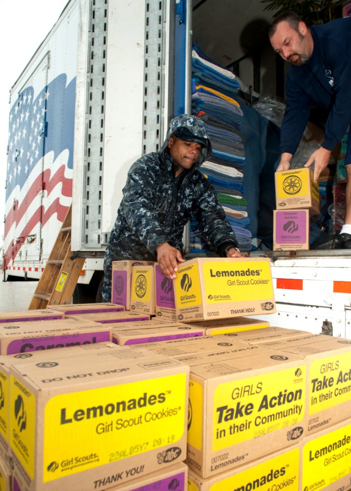 US Navy 110331-N-NY820-092 Culinary Specialist 1st Class Aaron Gilliam helps unload cases of Girl Scout cookies donated through the Troop to Troop