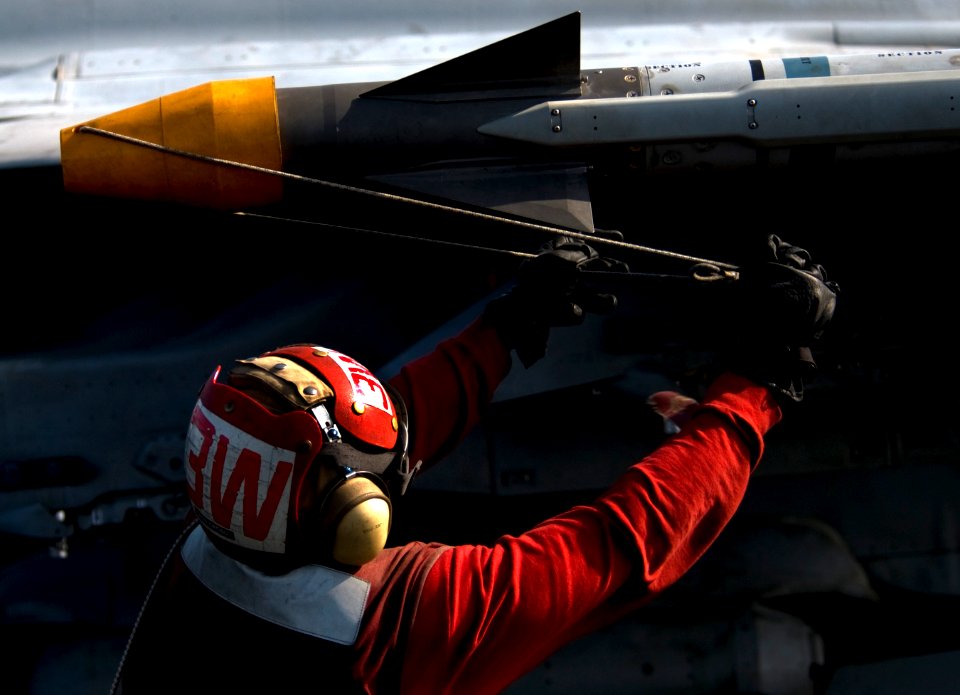 US Navy 110331-N-6320L-214 Aviation Ordnanceman 3rd Class Kwadjo Ofosu places a safety cap on ordnance on an F-A-18C Hornet aboard USS Carl Vinson