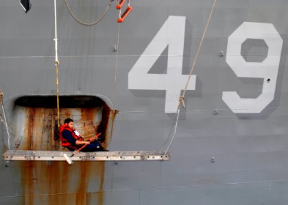US Navy 110326-N-HI707-303 Boatswain's Mate 3rd Class Anthony Woo waits for a bucket of paint to be lowered during a repainting evolution aboard th