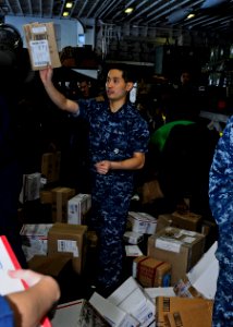 US Navy 110401-N-3154P-191 Religious Programs Specialist Seaman Andy Phan sorts and passes out mail aboard the amphibious assault ship USS Kearsarg