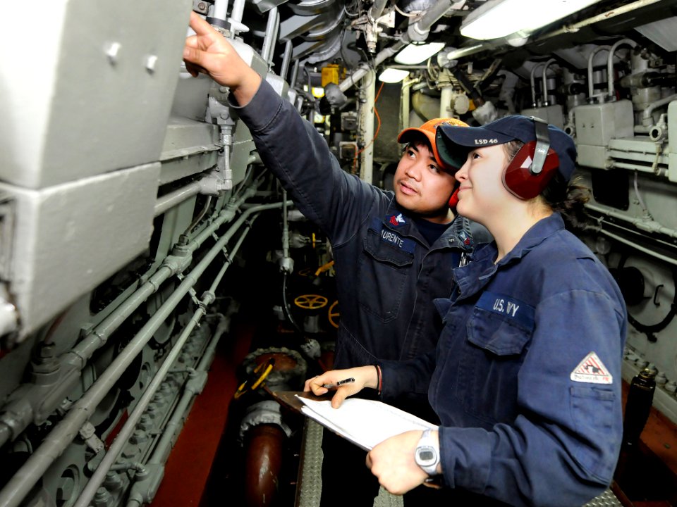 US Navy 110328-N-5716H-157 Engineman 1st Class Jerron Laurente, left, talks with Engineman Fireman Jennifer Garcia about guage levels in the engine