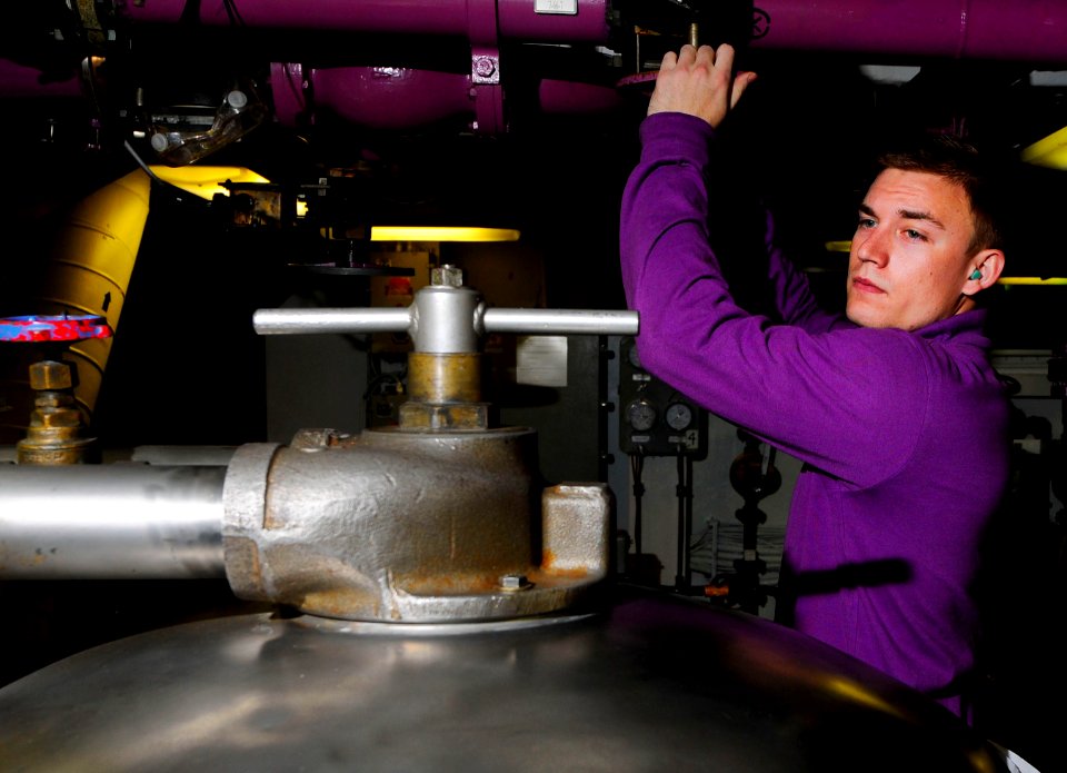 US Navy 110330-N-7488A-031 Aviation Boatswain's Mate (Fuel) Airman Jesse Malm opens an inlet to a fuel purifier in JP-5 pump room No. 2