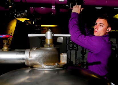 US Navy 110330-N-7488A-031 Aviation Boatswain's Mate (Fuel) Airman Jesse Malm opens an inlet to a fuel purifier in JP-5 pump room No. 2