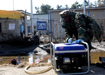 US Navy 110328-N-MU720-015 Builder 2nd Class Charles Hannah starts up a water eductor at fuel pumping station 2 as dewatering efforts continue