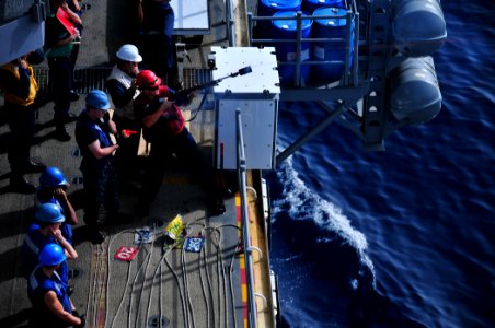 US Navy 110330-N-ZS029-092 Gunner's Mate 2nd Class John Carroll fires a shot line aboard the amphibious assault ship USS Boxer (LHD 4) to the Milit