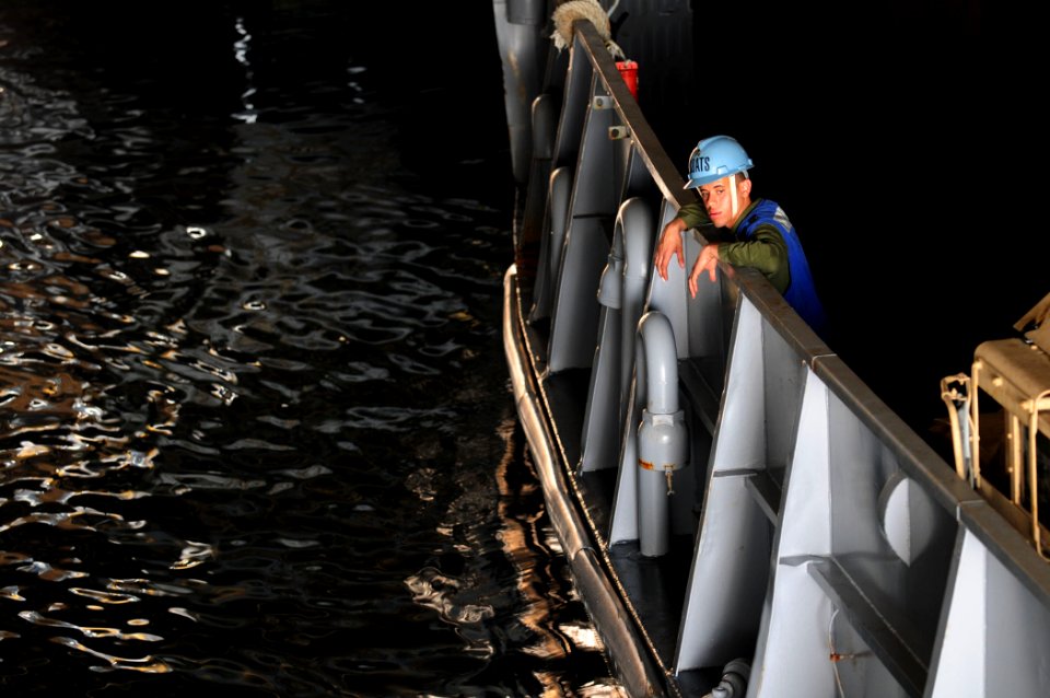 US Navy 110329-N-RC734-103 Boatswain's Mate Seaman Pablo Solano watches as lines are secured in the well deck aboard USS Comstock (LSD 45)