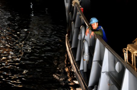 US Navy 110329-N-RC734-103 Boatswain's Mate Seaman Pablo Solano watches as lines are secured in the well deck aboard USS Comstock (LSD 45)