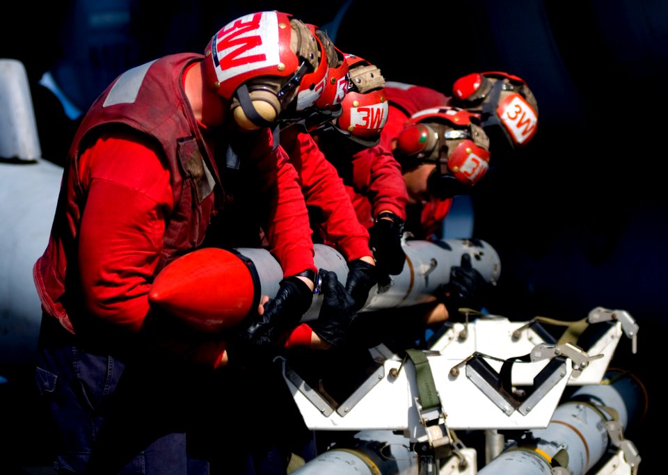 US Navy 110331-N-6320L-104 Aviation Ordnancemen assigned to Strike Fighter Squadron (VFA) 113 take ordnance off an F-A-18C Hornet aboard the Nimitz