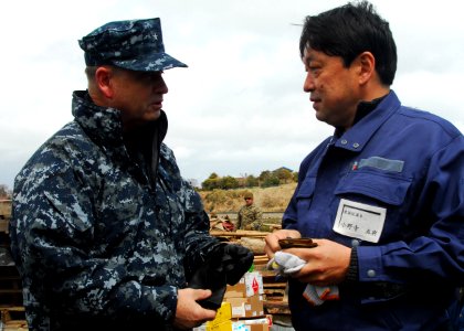 US Navy 110404-N-8607R-023 Rear Adm. Jeffrey S. Jones speaks with a resident of Oshima, to discuss the progress of disaster relief operations