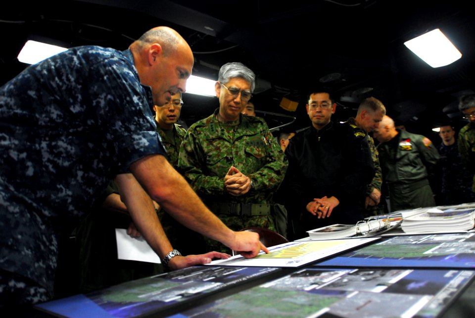 US Navy 110331-N-SB673-105 Rear Adm. Robert Girrier explains operations supporting earthquake and tsunami relief efforts to Lt. Gen. Eiji Kimizuka