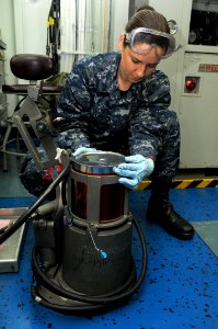 US Navy 110401-N-1004S-001 Aviation Structural Mechanic Airman Marcella West places a hydraulic canister into a hydraulic servicing unit aboard USS