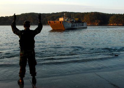 US Navy 110403-N-8607R-047 Engineman 2nd Class Ryan Grubbs directs Landing Craft Utility (LCU) 1634 as it brings Sailors and Marines ashore to help