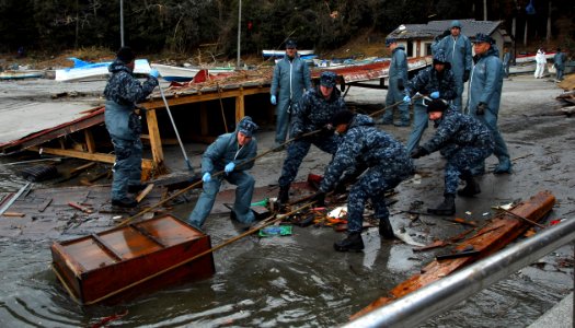 US Navy 110403-N-8607R-246 Sailors clean up debris from a harbor in Oshima, Japan