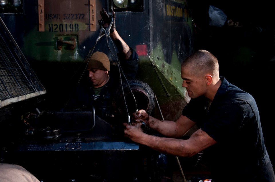 US Navy 110406-N-QP268-162 Lance Cpl. Taylor Fenderson, right, and Lance Cpl. Chris Arbino hook lifting straps to a amphibious assault vehicle (AAV