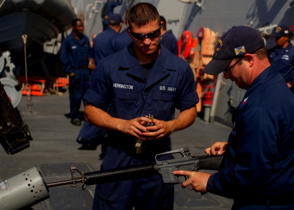 US Navy 110404-N-MM360-247 Gunner's Mate Seaman Robert Herrington observes as Gunner's Mate 1st Class Michael Solomon demonstrates clearing barrel