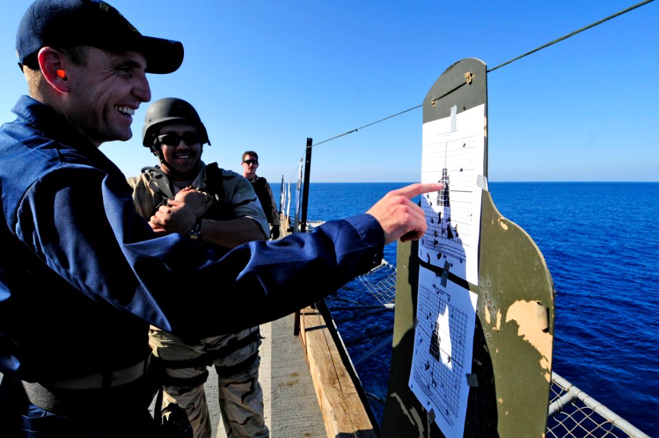 US Navy 110401-N-RC734-435 Lt. Cmdr. Scott Tasin, executive officer of the amphibious dock landing ship USS Comstock (LSD 45), points out his shots