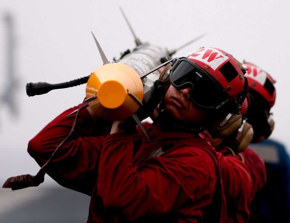 US Navy 110405-N-6505H-105 Sailors offload ordnance from an F-A-18E Super Hornet aboard USS Carl Vinson (CVN 70)